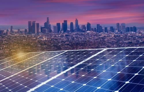 A solar panel at sunset with Los Angeles skyline in background